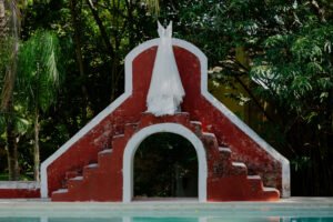 wedding dress hanging on top of the pool inthe middle of the garden in old hacienda in merida yucatan close to riviera maya just with the best wedding photographer